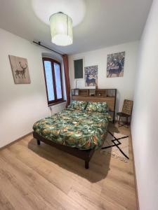 a bedroom with a bed and a desk and a window at T2 centre Ville Proche des pistes in Briançon