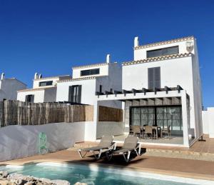 a white house with a swimming pool in front of it at Villa Son Blanc 5 in Sa Caleta +13 photos