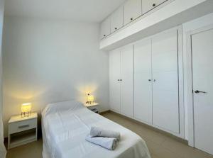 a white bedroom with a bed and white cabinets at Villa Son Blanc 5 in Sa Caleta