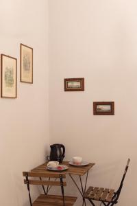 un tavolo in una stanza con bollitore per il tè e tazze appese a una parete di B&B Dei Decumani a Napoli