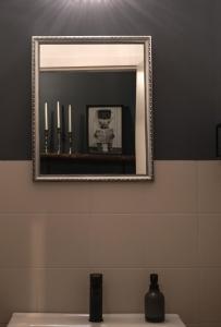 un bagno con specchio sopra un lavandino di Exklusives Stadthaus-Apartment am Staatstheather a Cottbus