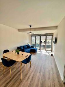 バニョレにあるMagnificent apartment Paris Bagnolet 302のテーブルと青いソファのあるリビングルーム