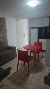 sala de estar con mesa roja y sillas en Flat em Recife, en Recife