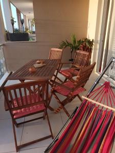 OceanDream Beach House Apartment في سال ري: طاولة وكراسي خشبية على شرفة