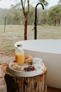 a tray of food sitting on top of a tree stump at Akuna Estate - Luxury Glamping Experience in Excelsior