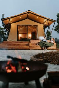 duas pessoas sentadas em frente a uma tenda em Akuna Estate - Luxury Glamping Experience em Excelsior