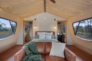 a bedroom in a tent with a bed and a couch at Akuna Estate - Adults Only Luxury Glamping Experience in Excelsior