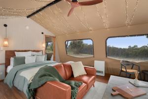 Excelsior的住宿－Akuna Estate - Luxury Glamping Experience，一间卧室配有一张床和一张沙发