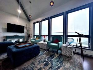 a living room with a couch and chairs and windows at Oceana Vista Escape - Beachside Haven in Dillon Beach