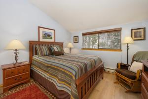 a bedroom with a bed and a chair and a window at Beaver Village Unit #0232R in Winter Park +12 photos
