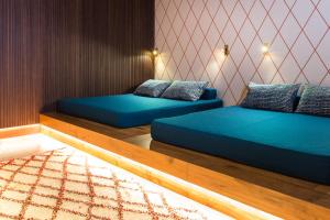 2 camas en una habitación con sábanas azules en ANTON Dolomites Hideaway, en Brunico