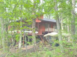 une grande maison rouge au milieu de la forêt dans l'établissement Sunland O66 - Vacation STAY 72793v, à Saikubo