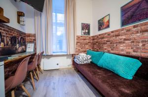 sala de estar con sofá y pared de ladrillo en Apartamenty Idylla, en Cracovia