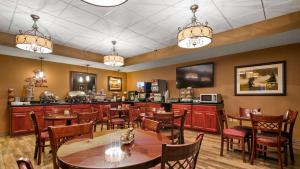 restauracja ze stołami i krzesłami oraz bar w obiekcie Best Western North Edge Inn w mieście Dodge City