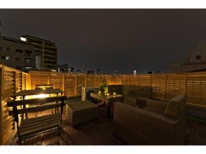 a balcony with a table and chairs on a roof at Mini Hotel Shinjuku Front - Vacation STAY 89794v in Tokyo
