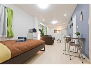 1 dormitorio con 1 cama, mesa y sillas en Mini Hotel Shinjuku Front - Vacation STAY 89794v, en Tokio