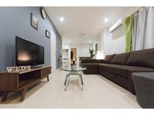 a living room with a couch and a tv at Mini Hotel Shinjuku Front - Vacation STAY 89794v in Tokyo