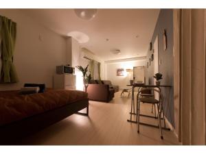 un soggiorno con letto e tavolo di Mini Hotel Shinjuku Front - Vacation STAY 89794v a Tokyo