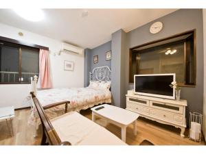 a living room with a bed and a tv at Mini Hotel Shinjuku Front - Vacation STAY 89788v in Tokyo