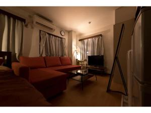 a living room with a couch and a tv at Mini Hotel Shinjuku Front - Vacation STAY 89774v in Tokyo