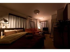 東京にあるMini Hotel Shinjuku Front - Vacation STAY 89774vのベッドルーム(ベッド1台、ソファ付) +4枚の写真