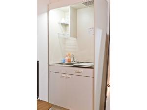 una pequeña cocina con lavabo y espejo en Mini Hotel Shinjuku Front - Vacation STAY 89774v en Tokio
