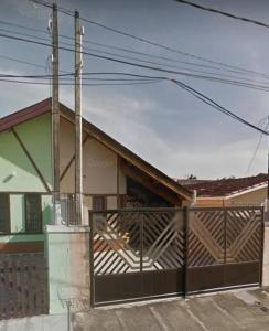 uma casa com um portão em frente a uma casa em Casa de praia da Terê em Peruíbe