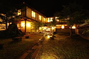 a house at night with lights in front of it at Tabinoyado Asonoyu in Aso