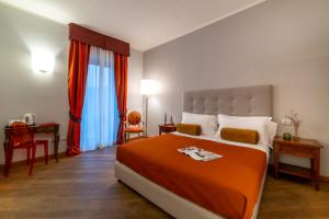 ein Schlafzimmer mit einem großen Bett mit einer orangefarbenen Decke in der Unterkunft Albergo Falterona in Stia