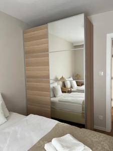 1 dormitorio con 2 camas y un espejo grande en Apartamenty Sosnowe przy Basenach Tropikalnych, Ładowarka do elektryków, Faktura, Parking, en Kielce