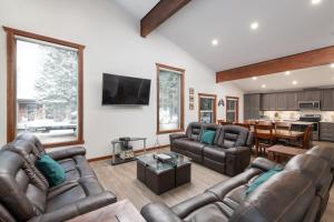 a living room with leather furniture and a kitchen at Aspen in Valemount