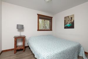 um quarto com uma cama e uma janela em Aspen em Valemount