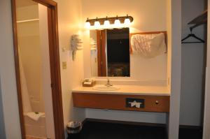 La salle de bains est pourvue d'un lavabo et d'un miroir. dans l'établissement Moriah Motel, à Sheridan