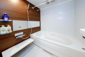 Baño blanco con bañera y lavamanos en Pacific Coast Katasekaigan - Vacation STAY 15738, en Fujisawa