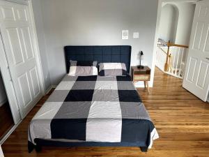 a bedroom with a bed with a black and white comforter at Luxury Stay in Montrose- The Italian Plaza in Houston