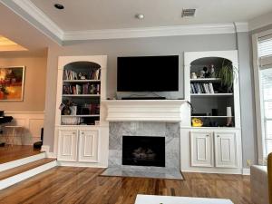 a living room with a fireplace with a flat screen tv at Luxury Stay in Montrose- The Italian Plaza in Houston