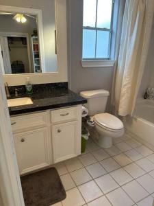 a bathroom with a toilet and a sink and a mirror at Luxury Stay in Montrose- The Italian Plaza in Houston