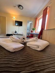 une chambre d'hôtel avec 2 serviettes sur un lit dans l'établissement Hotel-Pension Zur Mole, à Wiek auf Rügen
