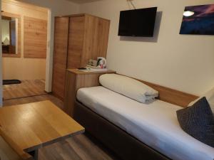 a small room with a bed and a tv at Haus Felsneck in Sölden