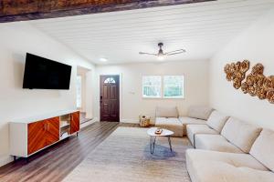 ein Wohnzimmer mit einem Sofa und einem Flachbild-TV in der Unterkunft The Sunset Pearl in Jacksonville Beach