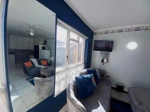 a living room with a couch and a mirror at Royal Classico Getaway in Strand Beach in Cape Town