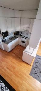 a kitchen with white appliances and a wooden floor at Upea saunallinen asunto järvinäkymällä. in Jyväskylä