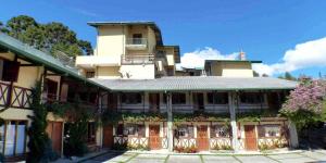 un grand bâtiment avec des fleurs devant lui dans l'établissement Pousada Alpes da Serra Campos do Jordão, à Campos do Jordão