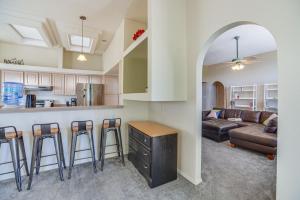 a kitchen and living room with a couch and a bar at Enchanted Hills Home with Sandia Mountain Views! in Rio Rancho