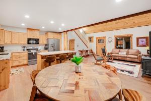 Il comprend une cuisine et un salon avec une table en bois. dans l'établissement Experience Montana Cabins - Lake View Luxury #7 & Dream Catcher Luxury #8, à Bigfork
