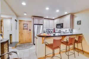 cocina con armarios de madera y barra con taburetes en Condo Near Golf Club about 2 Mi to Vail Ski Resort!, en Vail