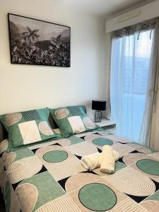 a bedroom with a large bed with green and white pillows at Cocon Eudenia - accès direct PARIS - 2 MIN RER - PARKING GRATUIT in Cergy