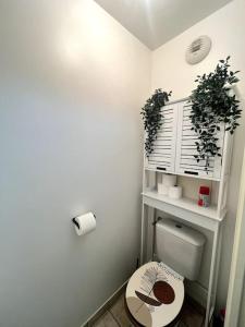 uma casa de banho com WC e uma prateleira com plantas em Cocon Eudenia - accès direct PARIS - 2 MIN RER - PARKING GRATUIT em Cergy