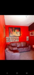 a living room with a couch in a red wall at Departamento Kassandra in Puerto Peñasco