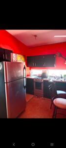 a kitchen with red walls and a stainless steel refrigerator at Departamento Kassandra in Puerto Peñasco +11 photos